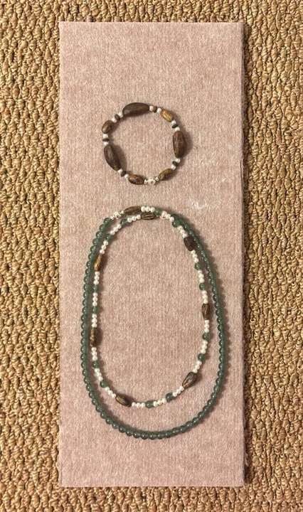 Necklace and bracelet pairing arranged on a blush felt board
