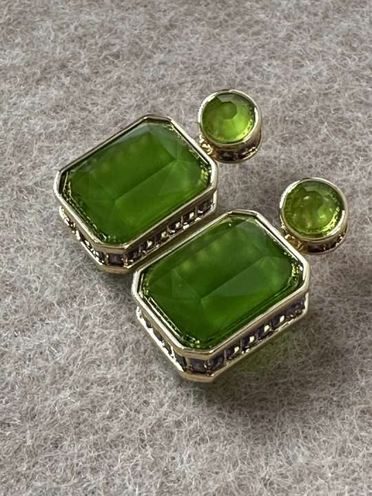 Green zircon earrings in a tactile close-up