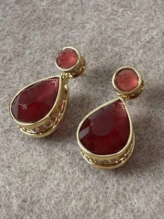 Red agate earrings in a warm tactile close-up