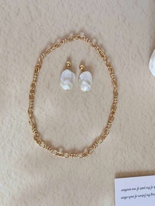 Gold-plated silver chain and baroque pearl earrings arranged together